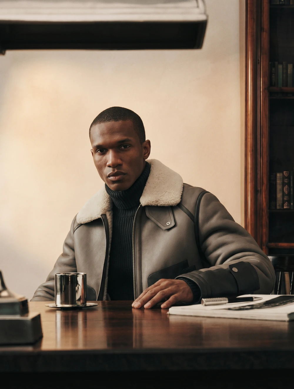Man seated at a desk, editorial portrait.