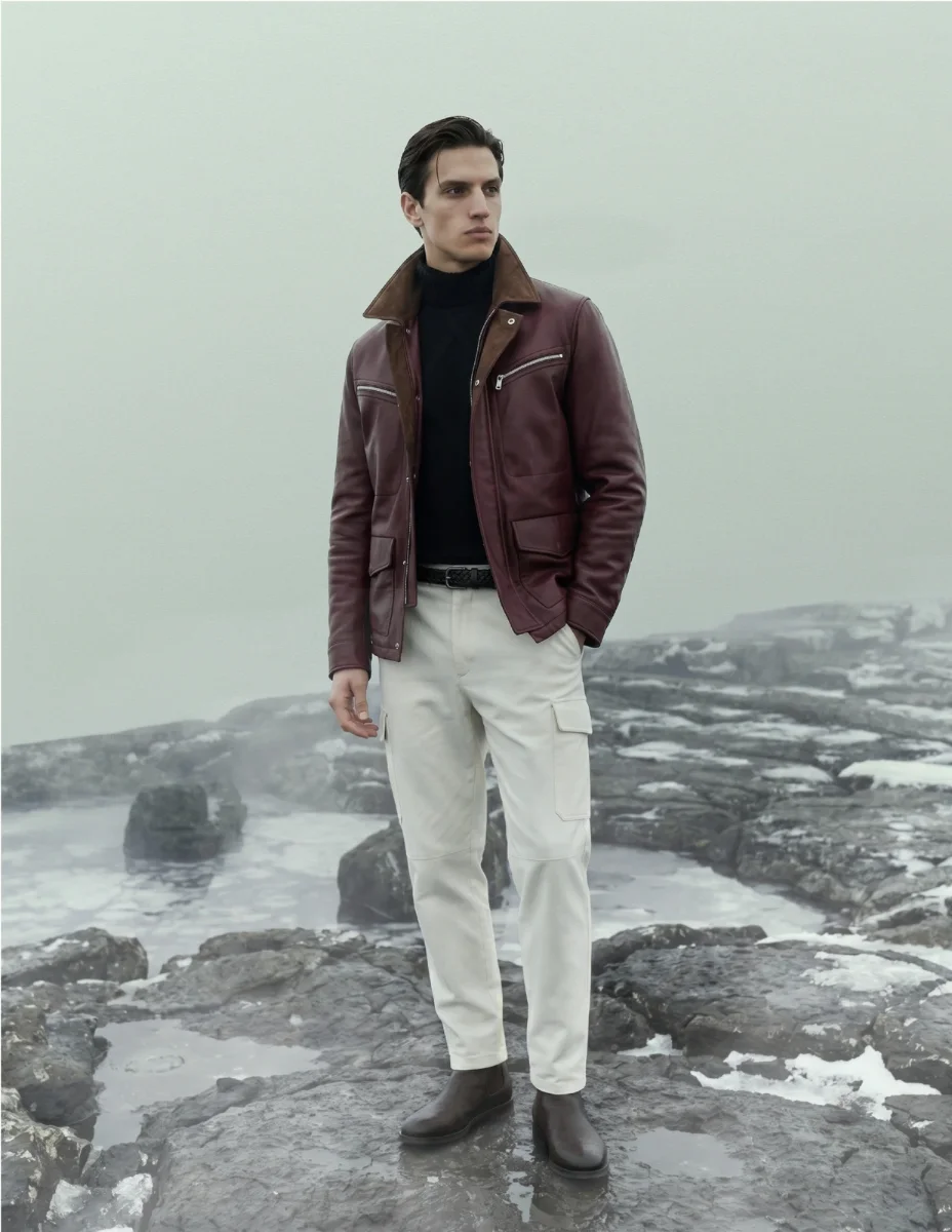 Brunello Cucinelli winter campaign, model in shearling against a warm wall.